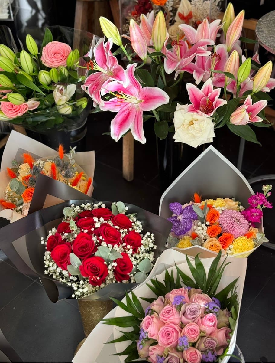 Étal de bouquets de lys et de roses à l'entrée de la boutique Laurence Fleurs, à Marseille 15e